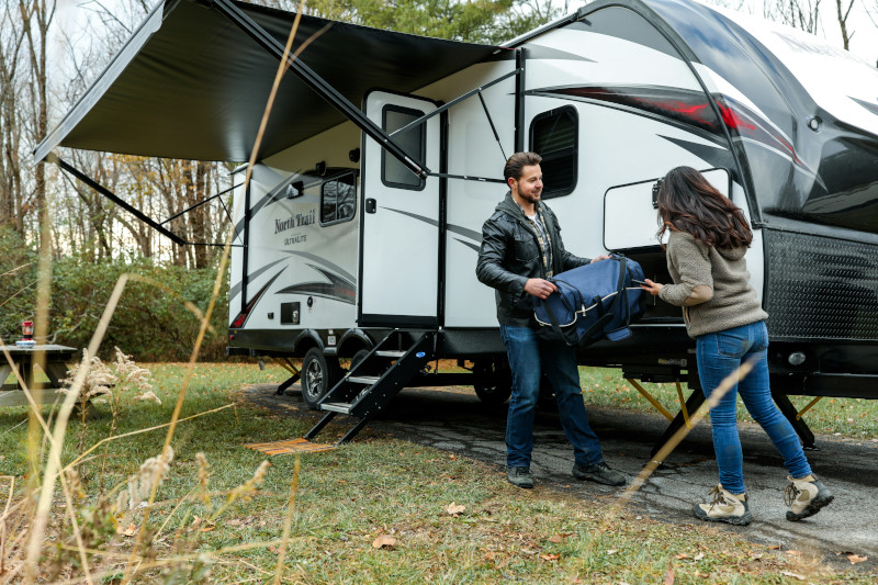 RV being setup by a young couple getting ready to camp